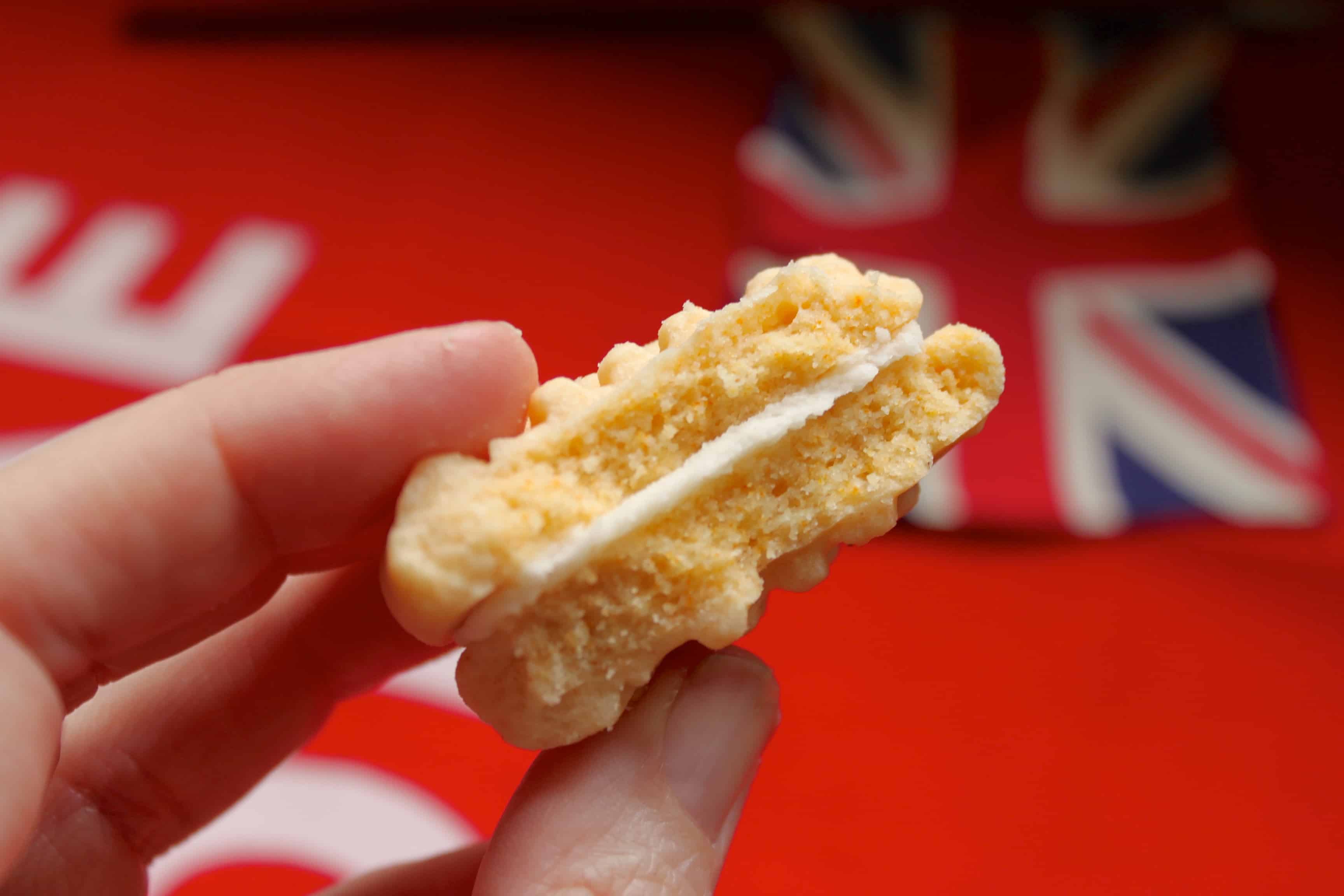 photo of a handheld, half eaten homemade Custard Cream biscuit.