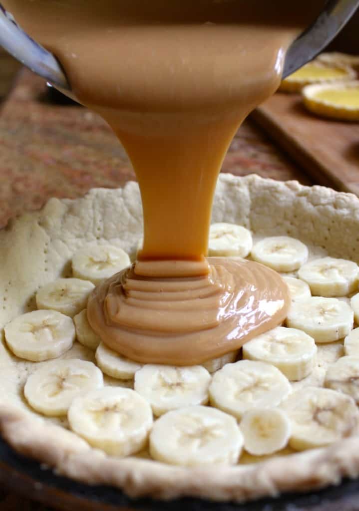 Pouring caramel into classic banoffee Pie