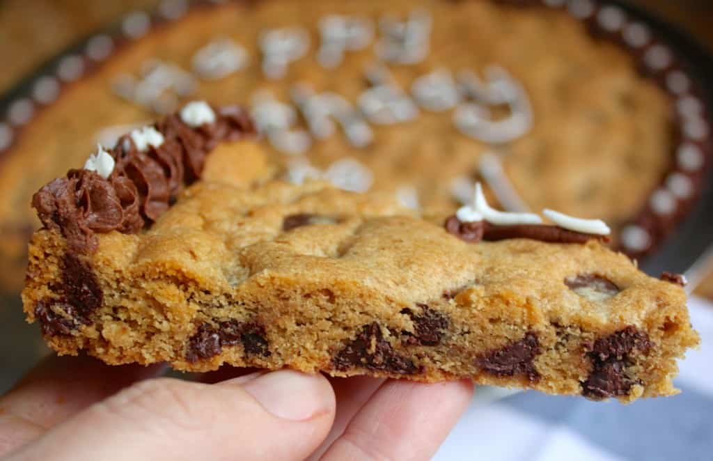 holding a slice of cookie cake