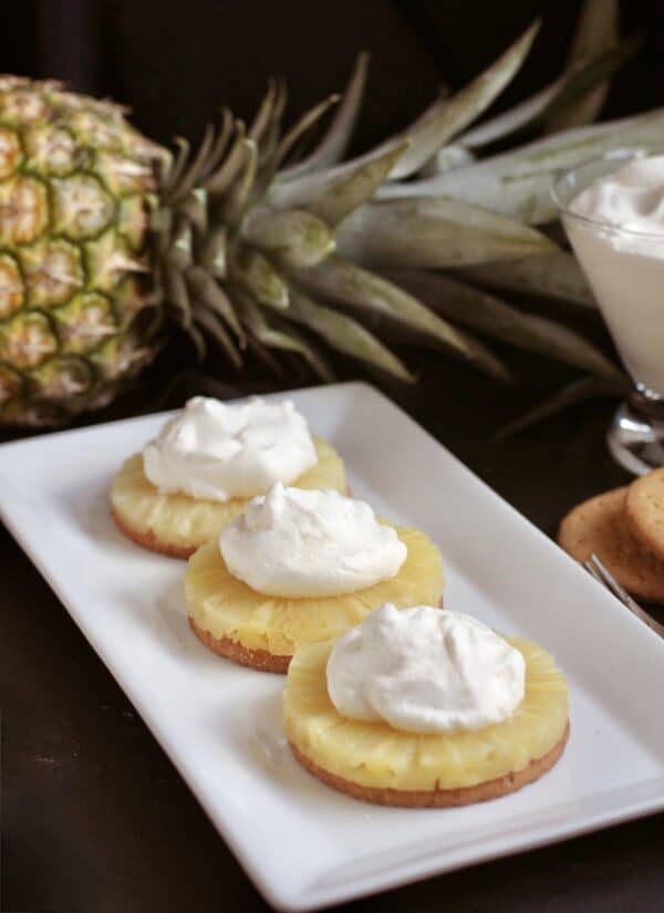 no bake pineapple dream dessert on a white tray with a pineapple