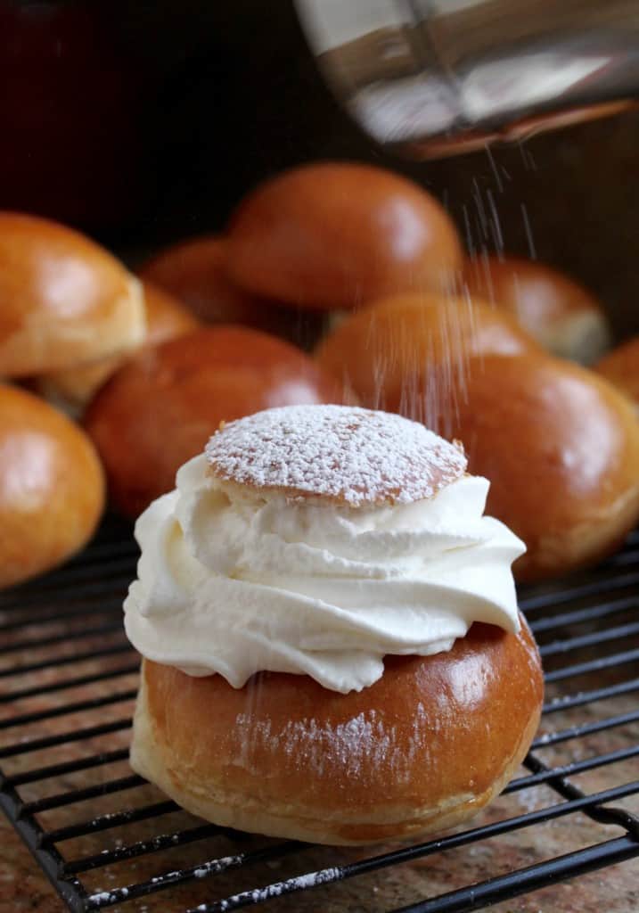 Dusting semla with powdered sugar