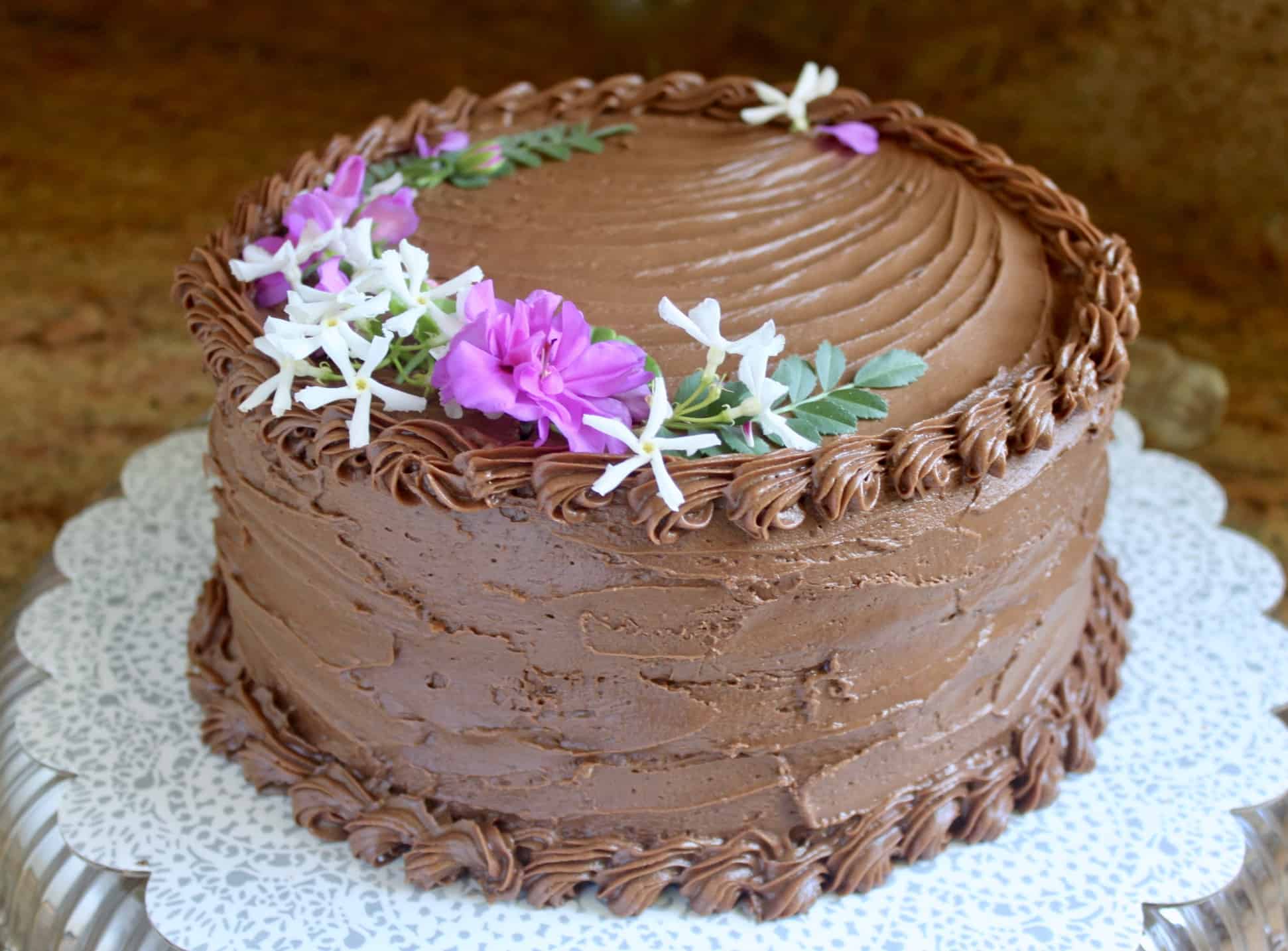 moist chocolate cake recipe with edible flowers on top