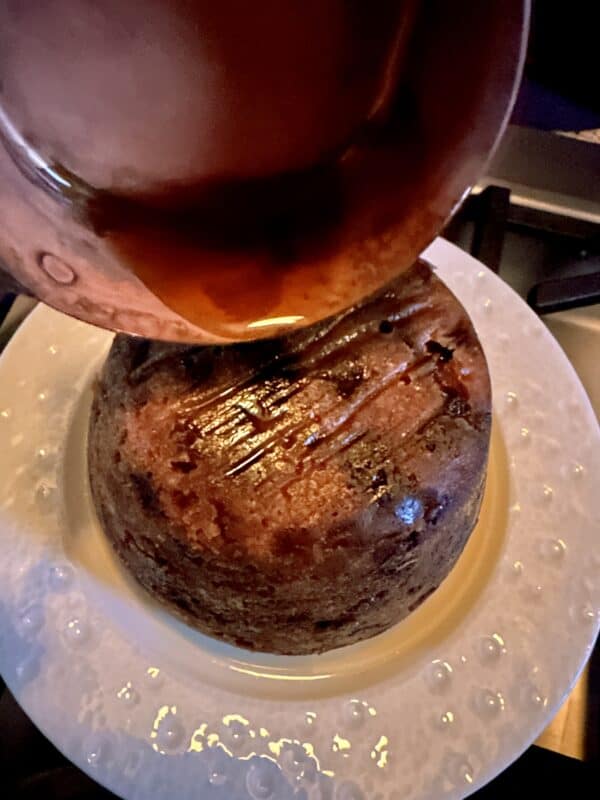 pouring alcohol on a Christmas pudding