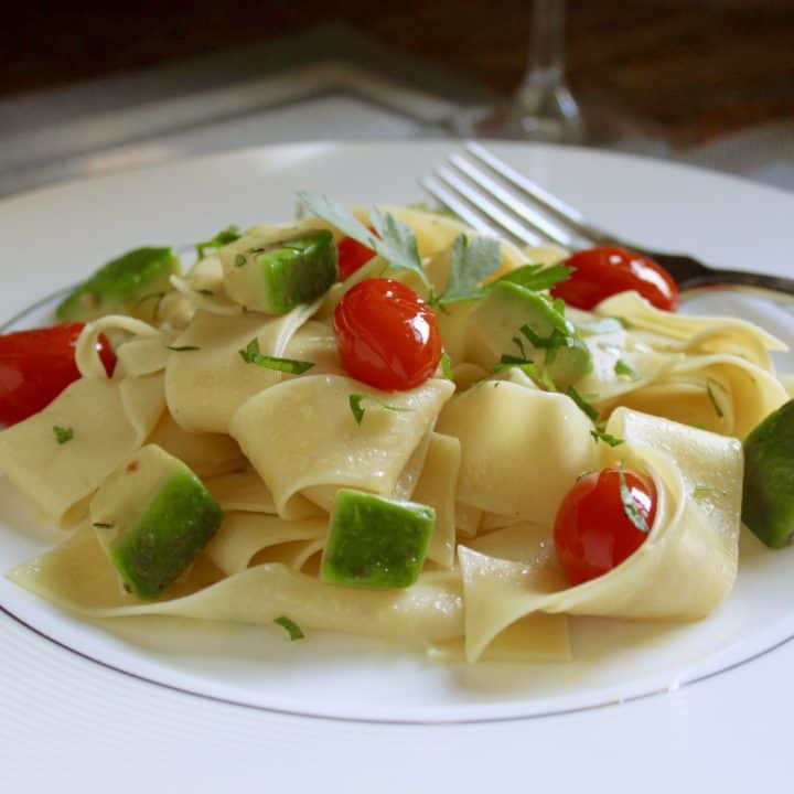 Egg pasta dish with avocado and tomatoes