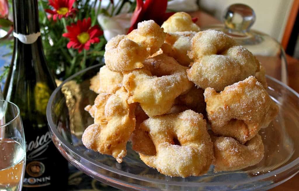 Doughnuts italianos da véspera de Natal numa pilha num tabuleiro de bolos