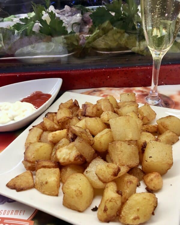 Patatas bravas and a glass of Cava at La Boqueria market