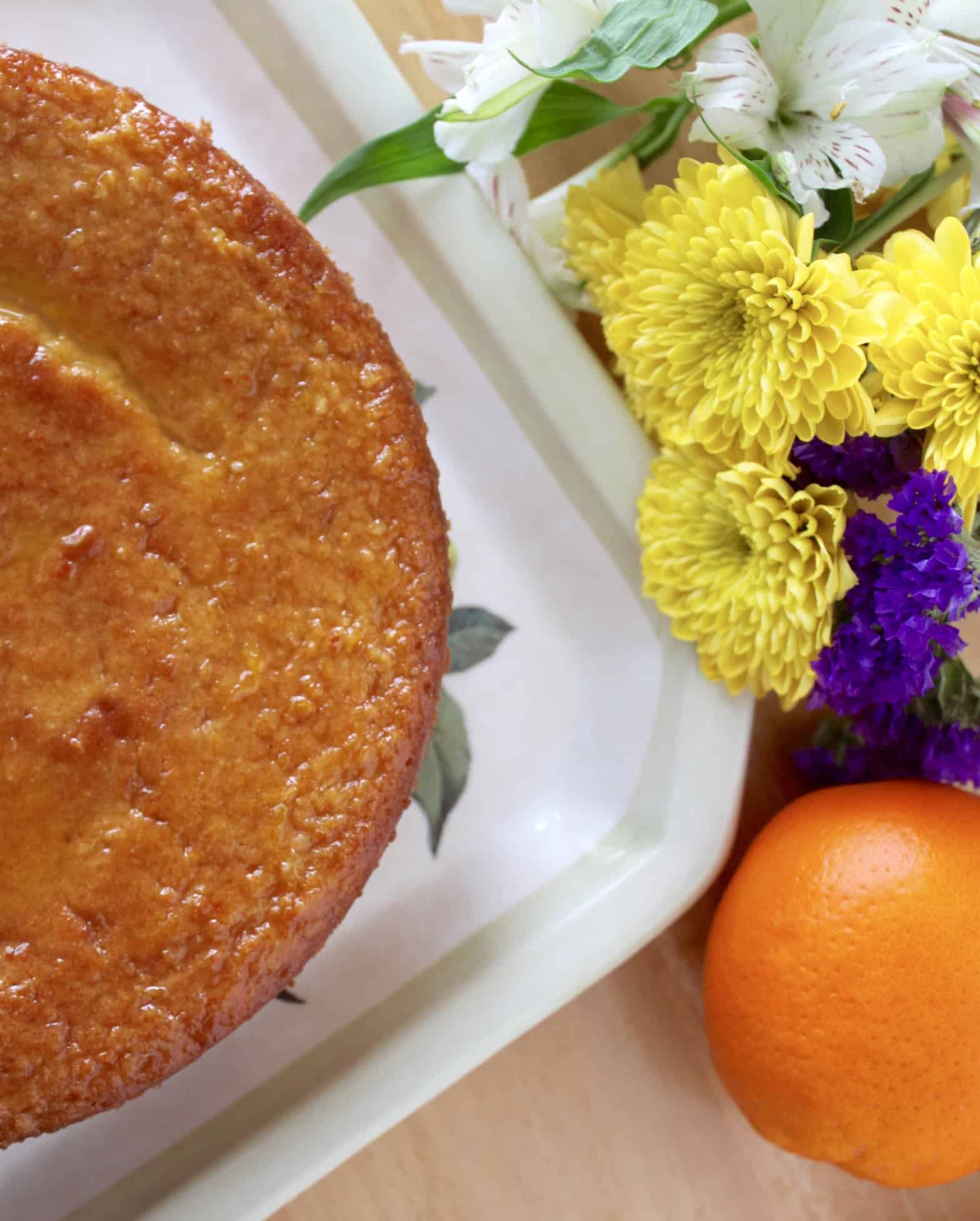 Sicilian Orange Cake on a plate with orange and flowers