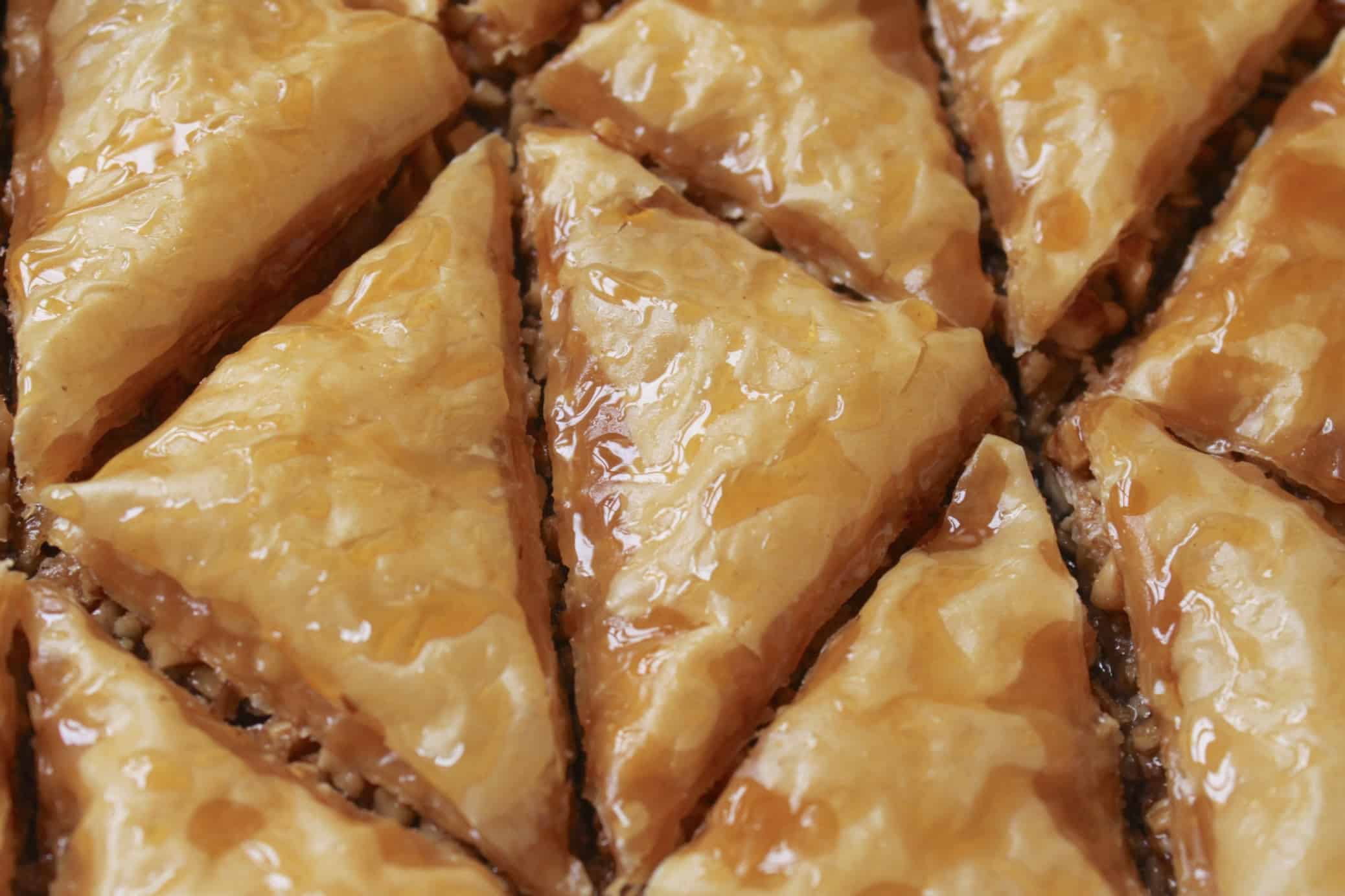 pieces of baklava in tray with honey on top