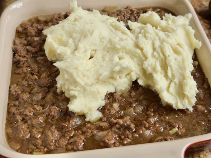 adding potatoes to meat