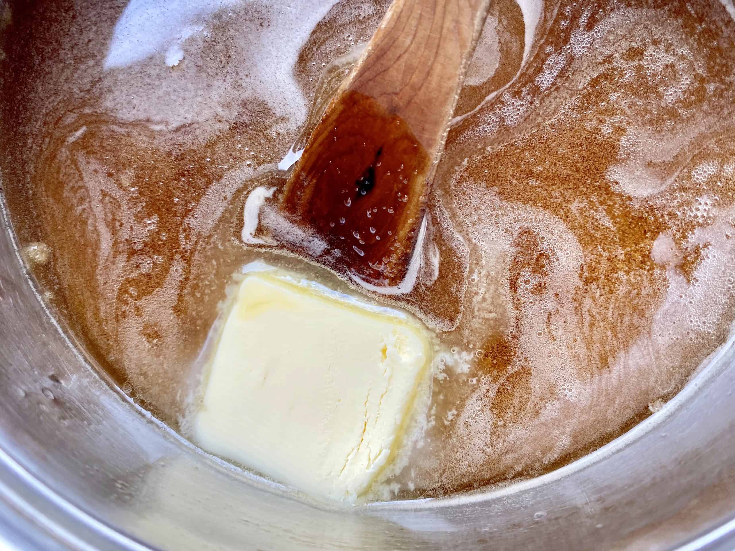 adding butter to sugars in pot