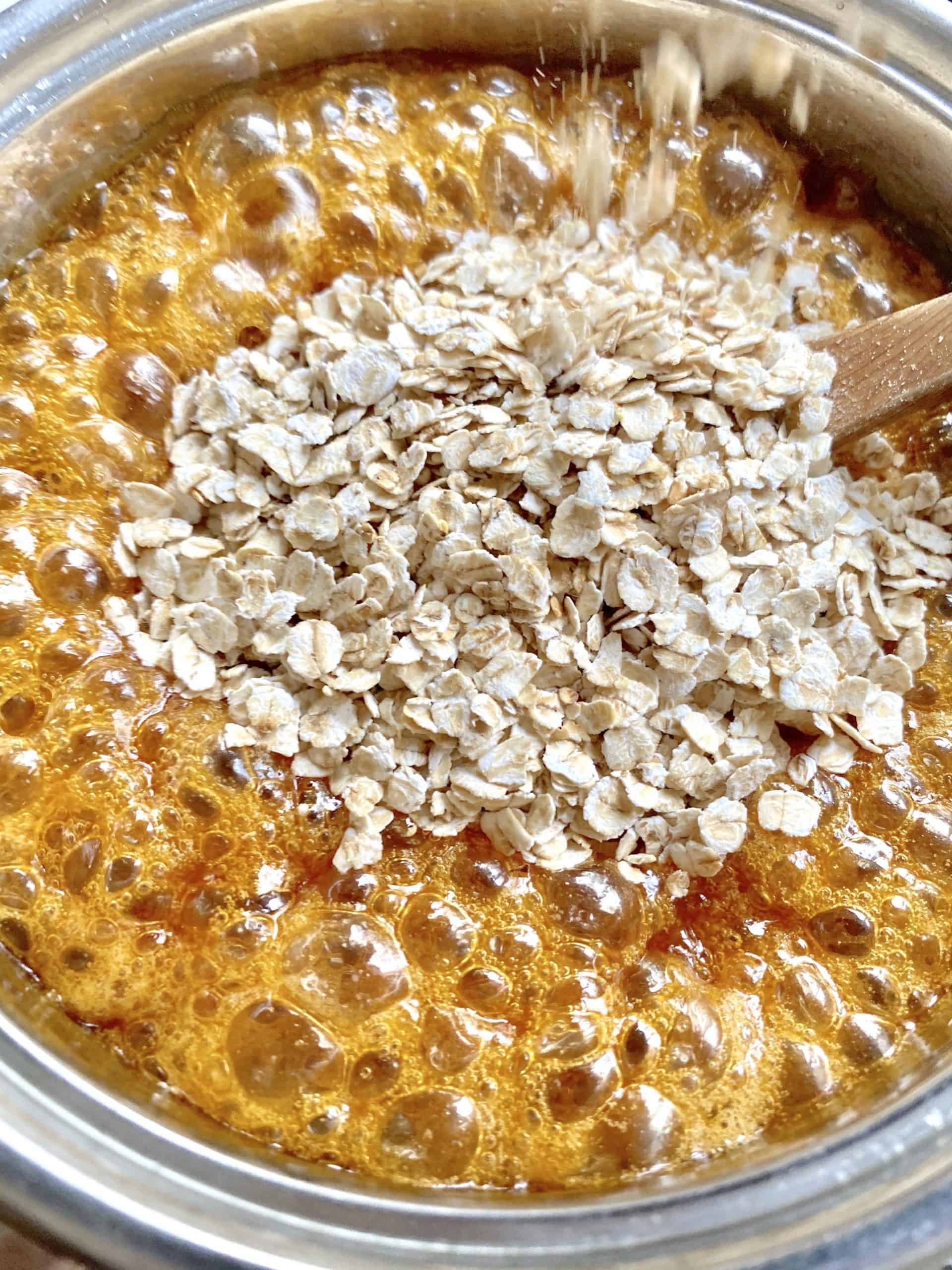 adding oats to bubbling sugar syrup