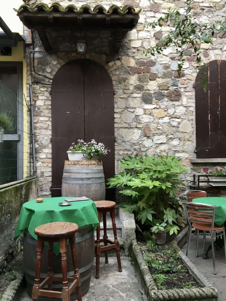 Pretty outdoor area with barrel, table and chairs in Sirmione