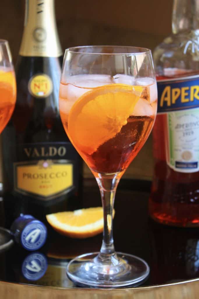  an Aperol Spritz with bottles in the background