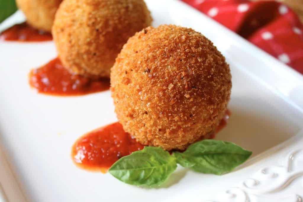 arancini on a plate with basil