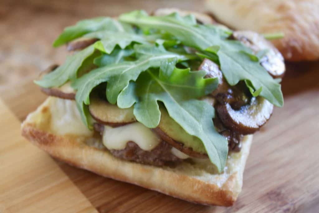 adding arugula to the top of the mushrooms