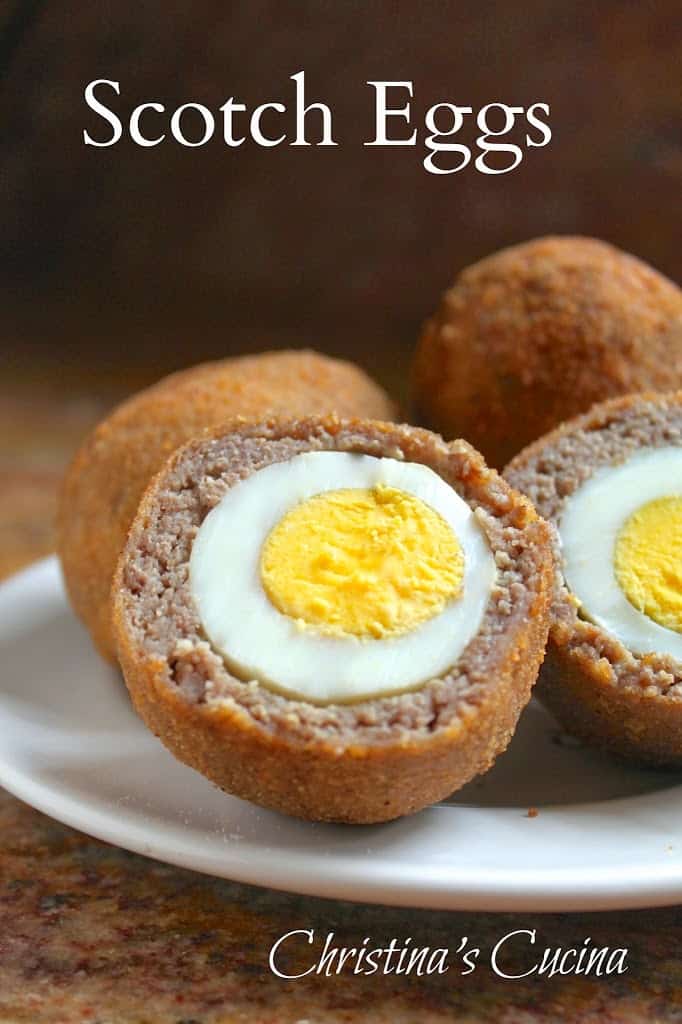 Homemade Scotch eggs on a plate, one cut in half