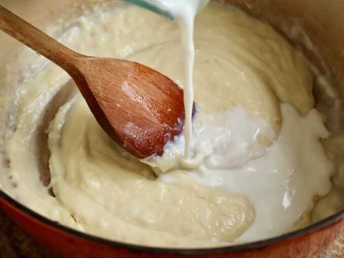 adding milk to white sauce