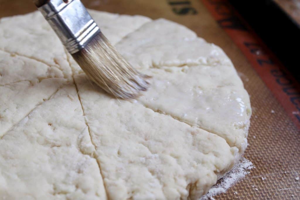 brushing dough round with milk