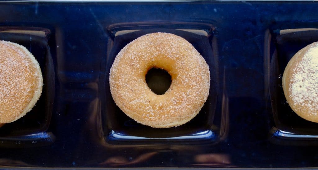 drie vegan donuts op een rij met suiker