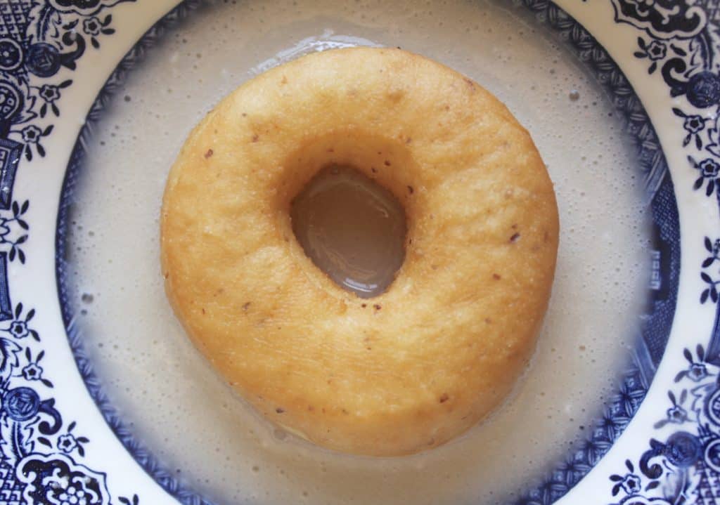 Dipping vegan doughnuts in glaze