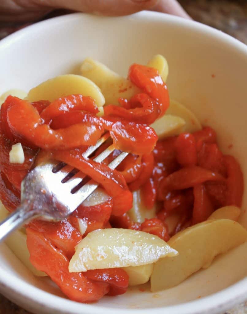 Mixing potato and roasted red pepper salad