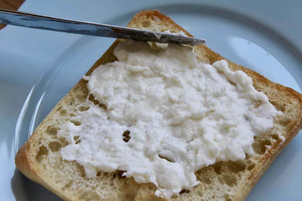 spreading burrata on toast