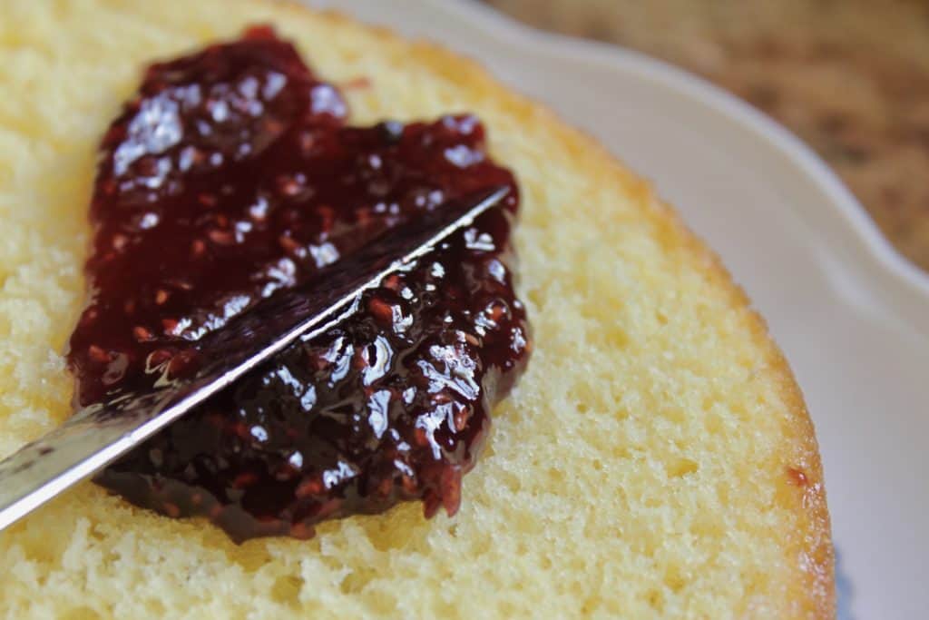 spreading jam on cake