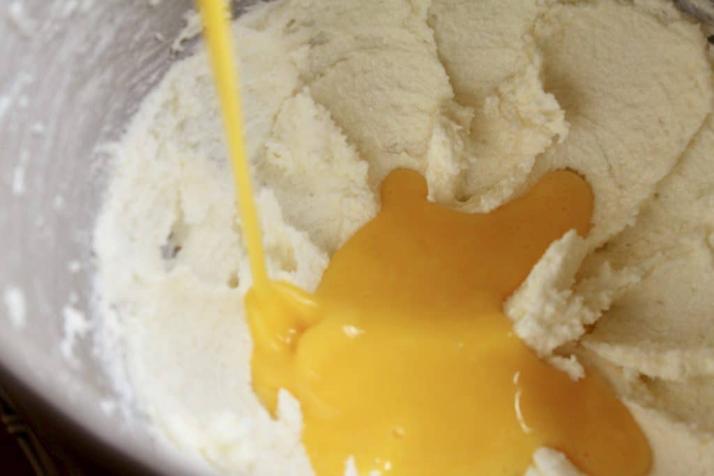 adding beaten eggs to creamed butter and sugar