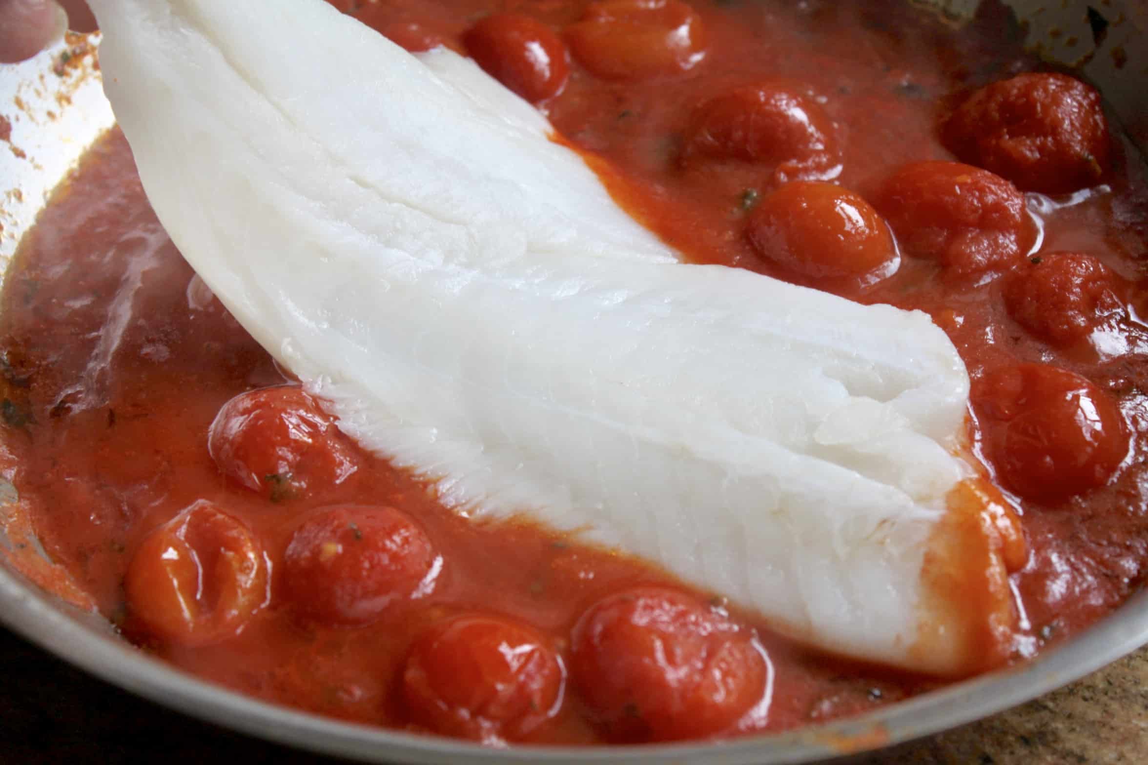 adding fish into the tomato sauce