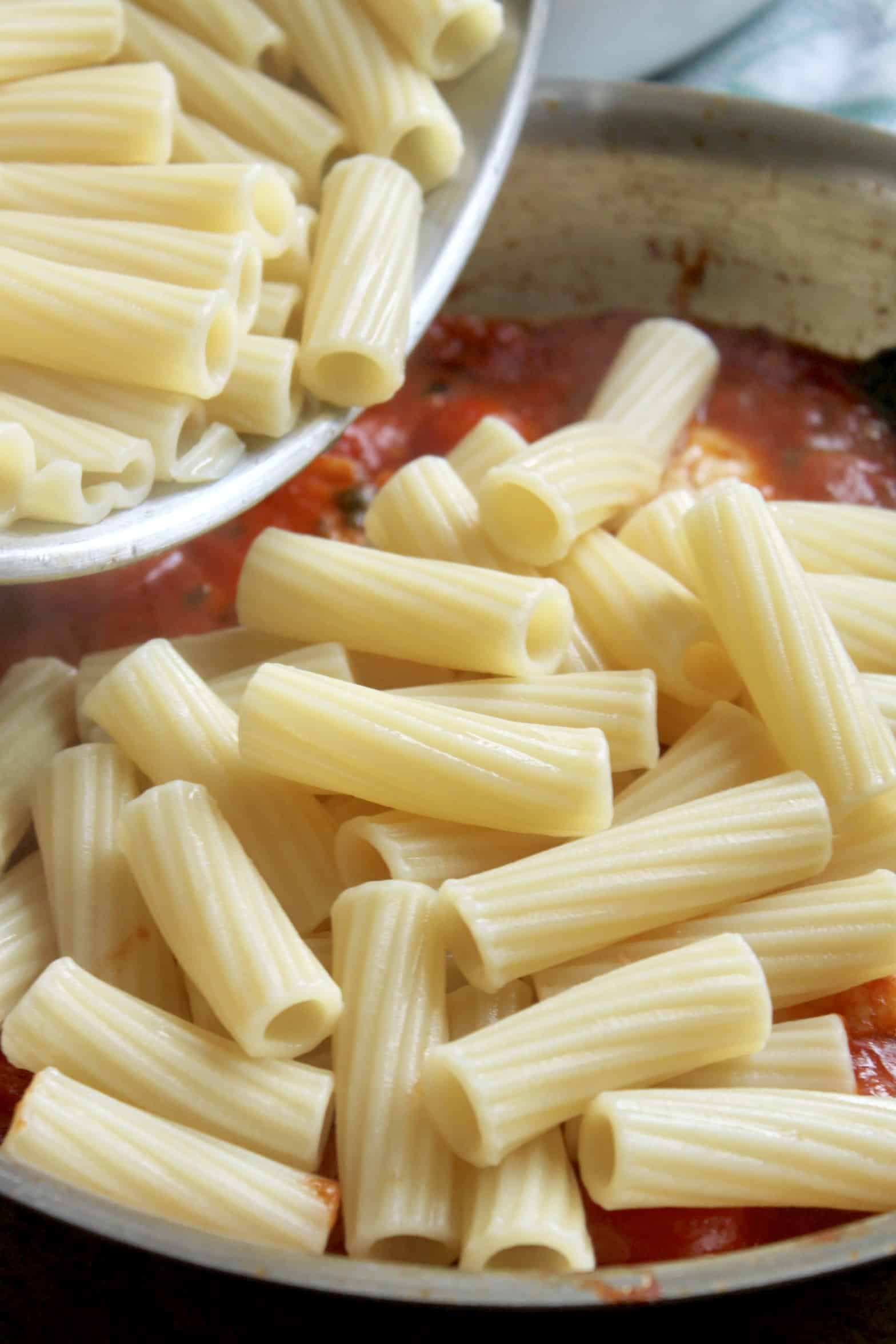 pasta going into the sauce