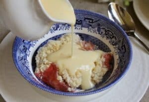 pouring custard on crumble