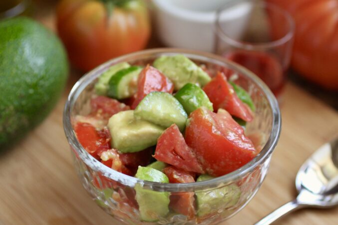 cucumber tomato and avocado salad in glass bowl