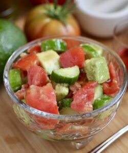 cucumber tomato and avocado salad in glass bowl