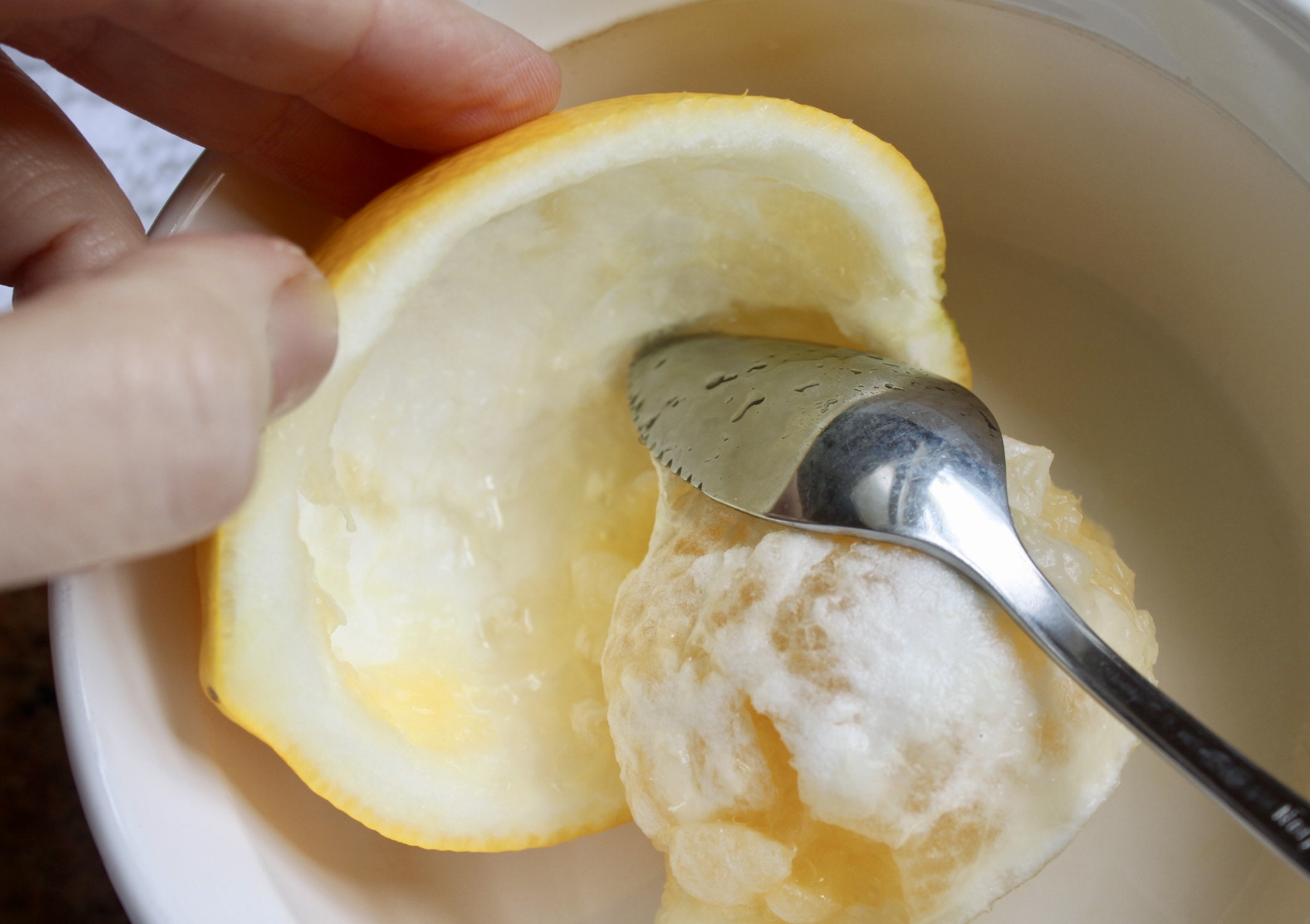 scooping out the flesh of a citrus fruit