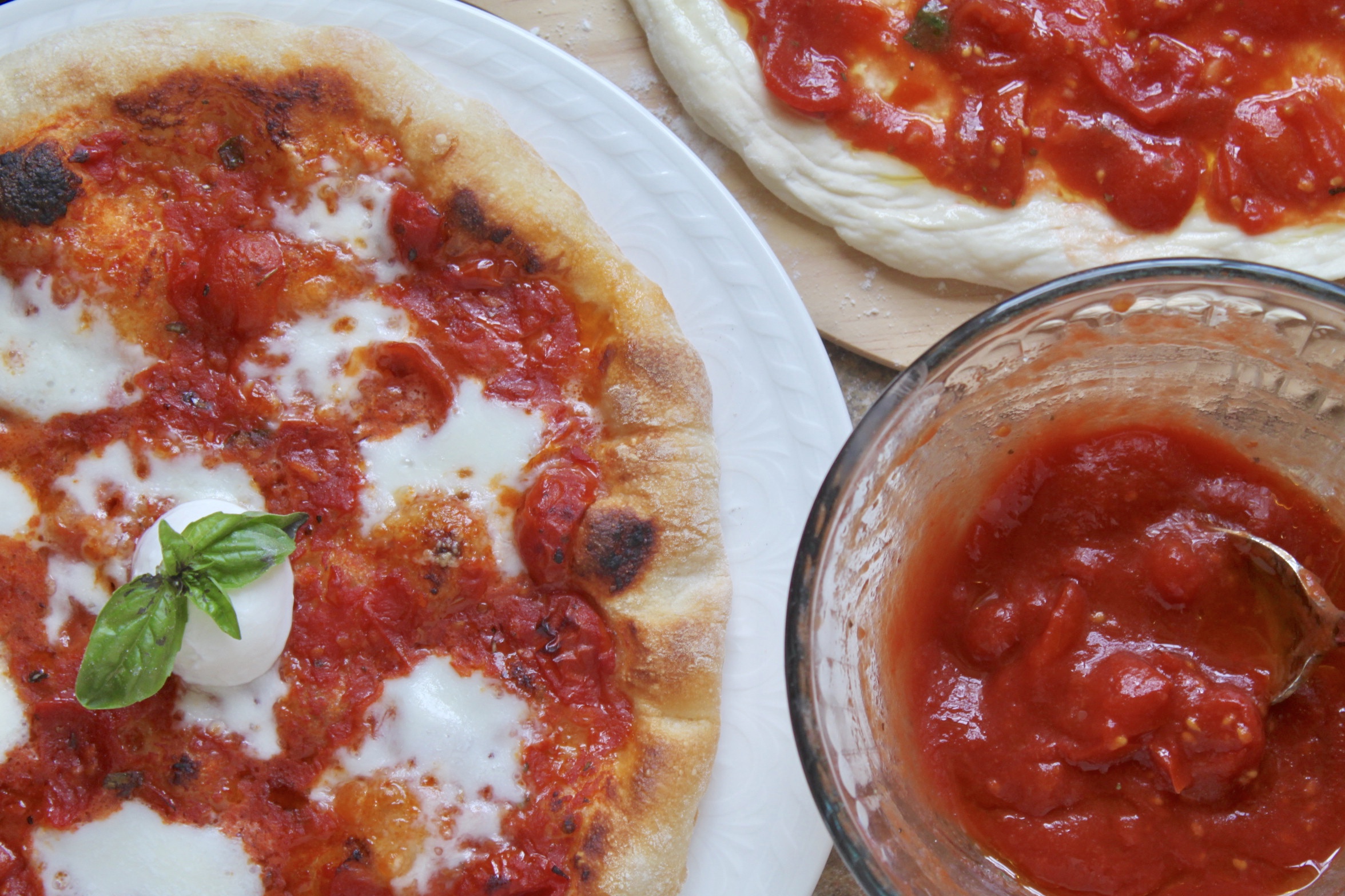 cooked pizza, raw pizza and pizza sauce