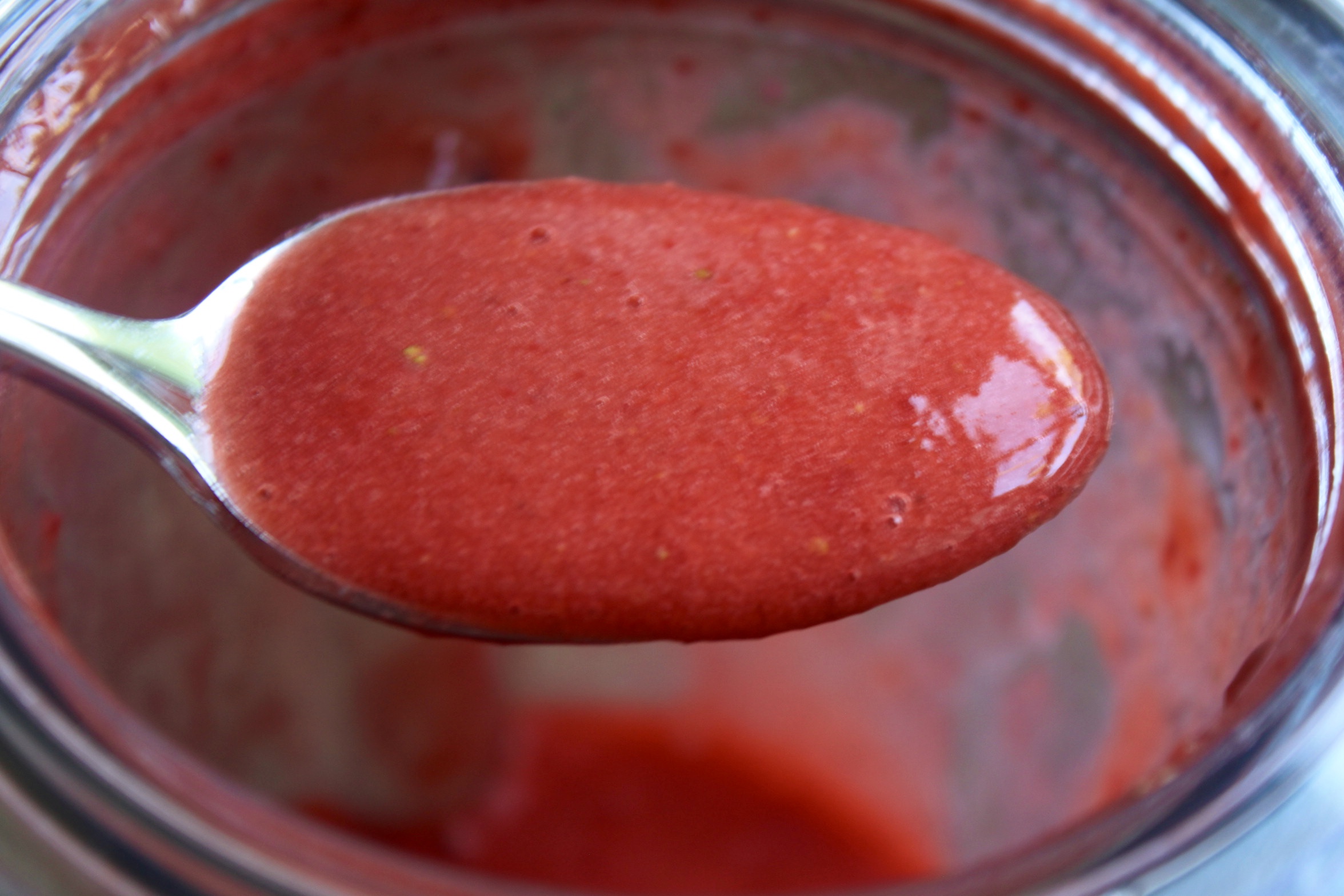 pureed strawberries in a spoon