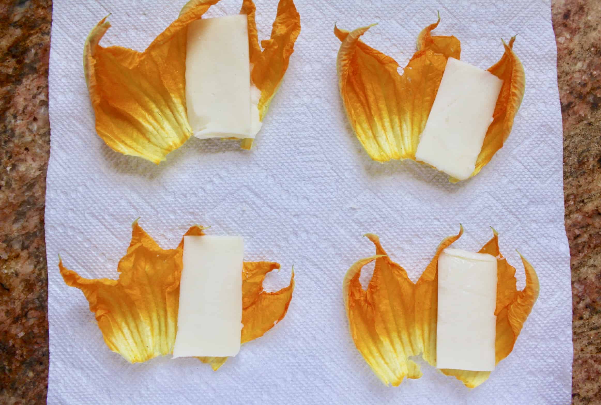 putting mozzarella inside the zucchini flowers