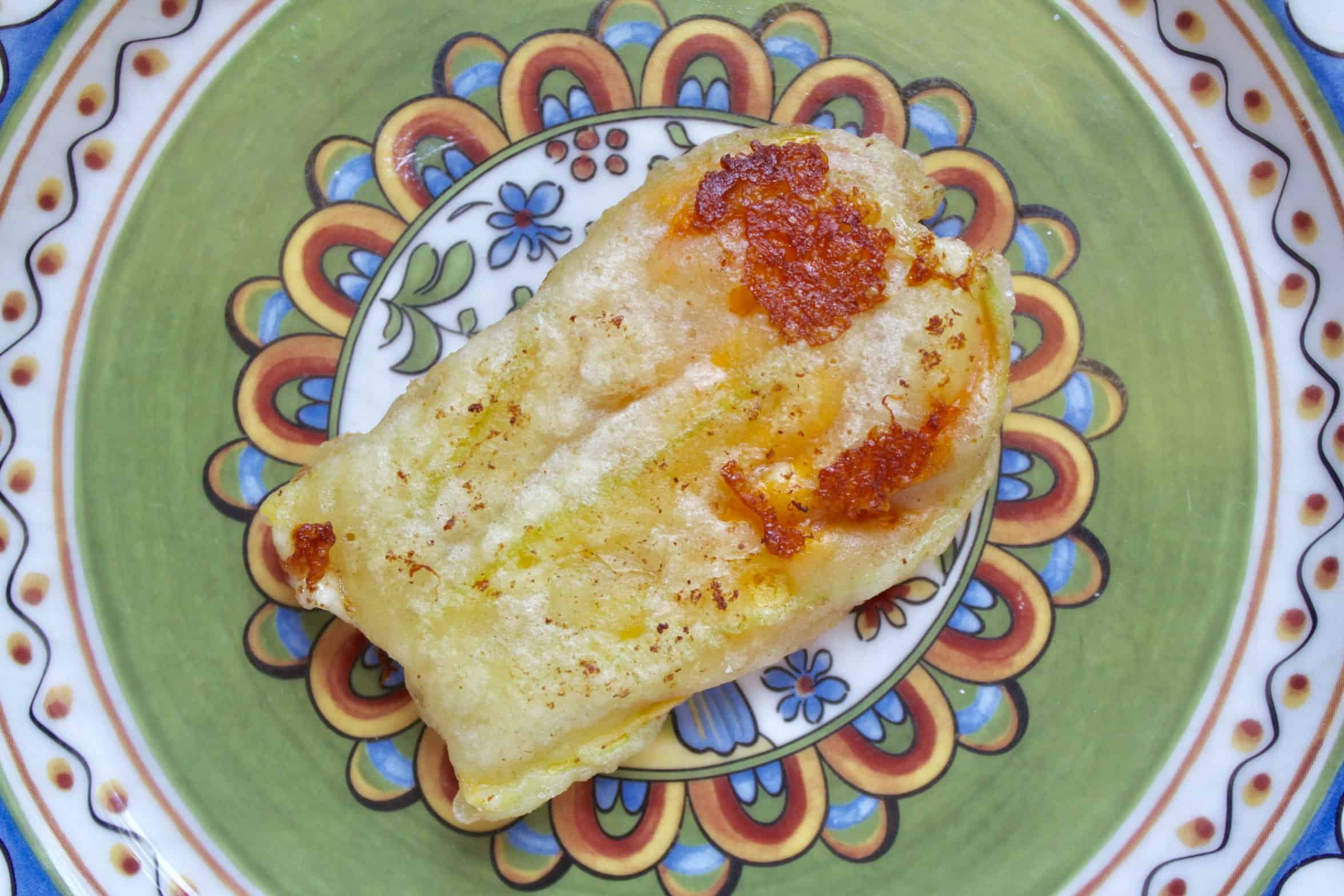 fried zucchini flower stuffed with cheese on a pretty plate