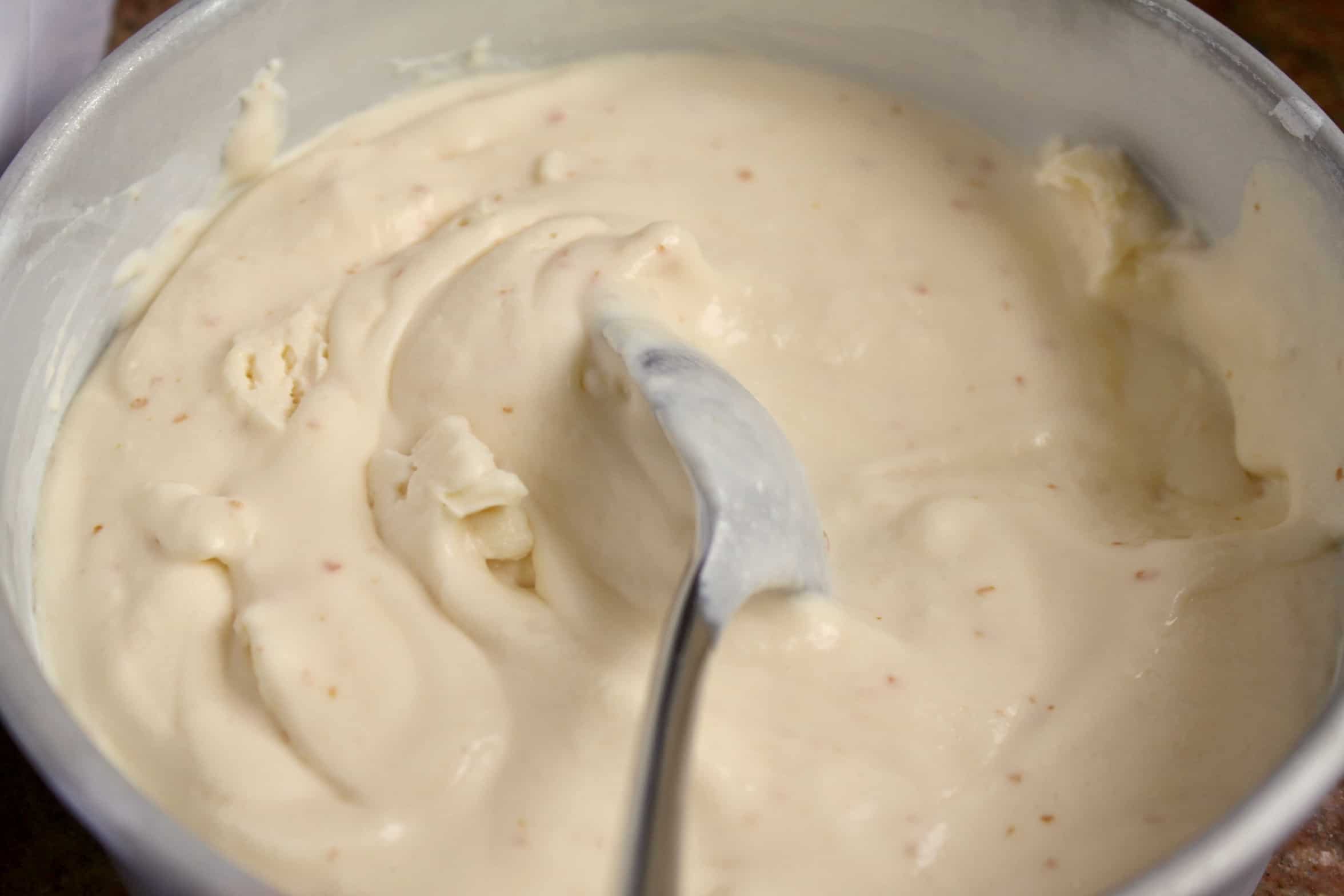 mixing the partially frozen orange cream mixture with a spoon