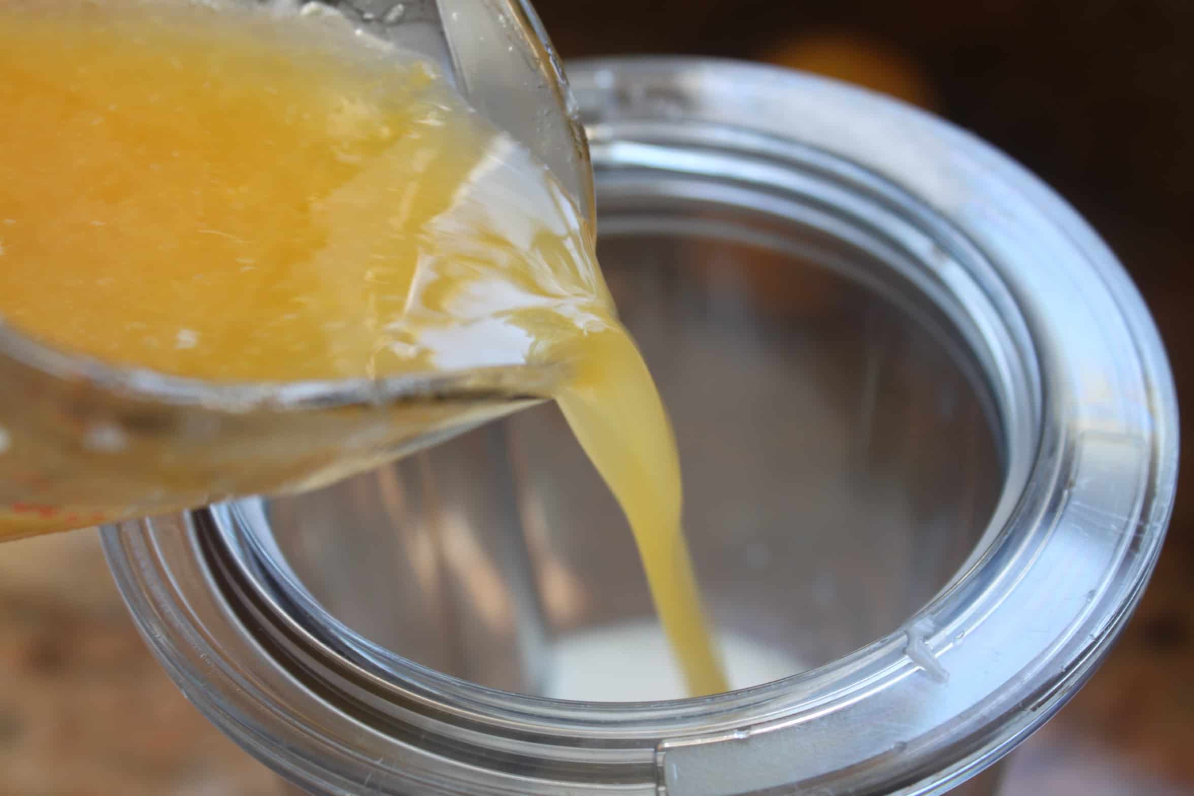 pouring orange juice into blender container