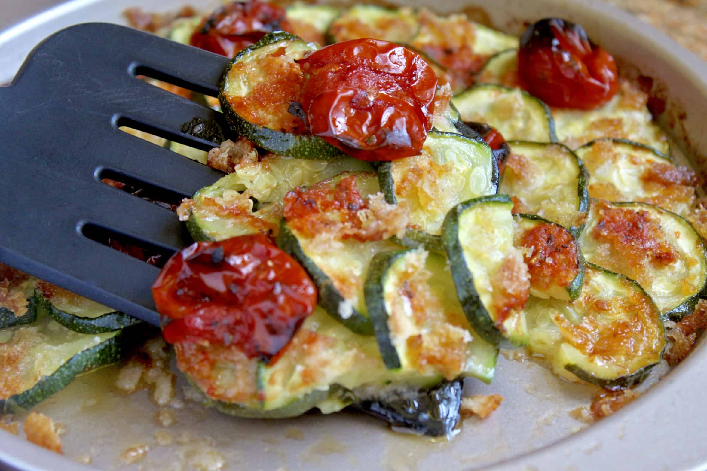 baked zucchini and tomatoes on a spatula