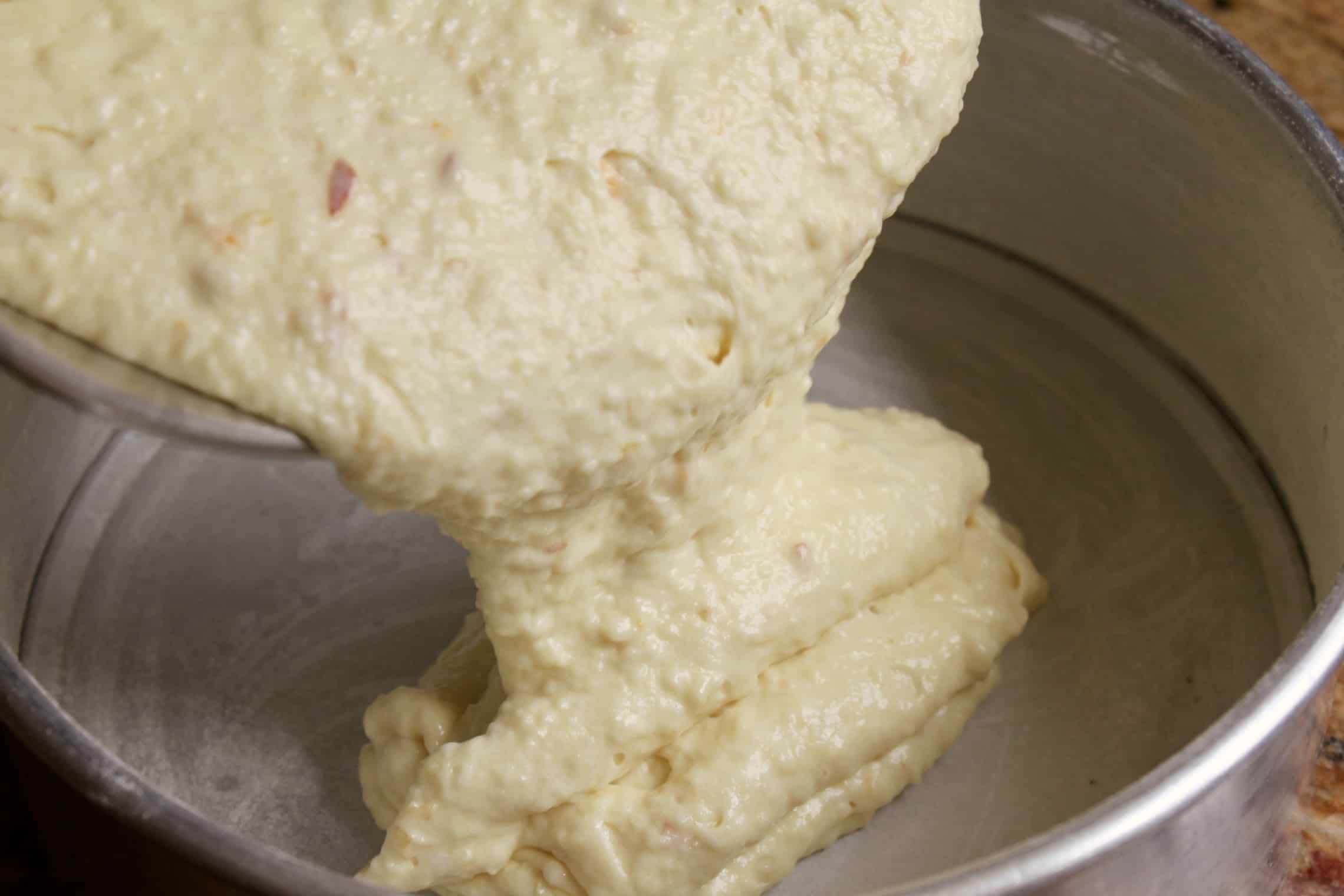 pouring no peel apple cake batter into cake tin