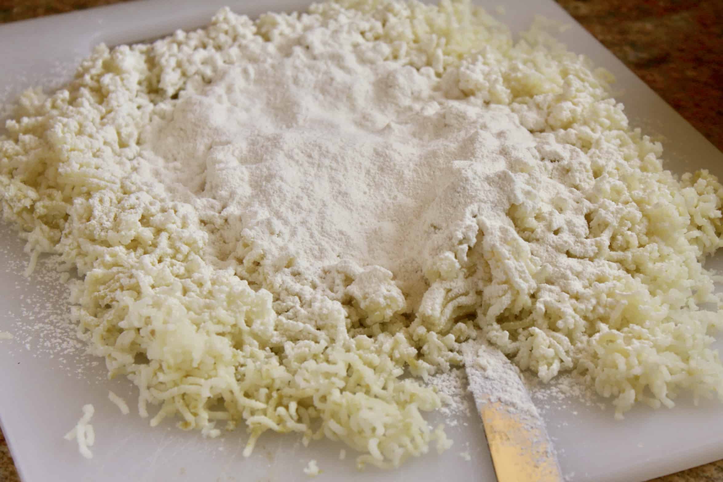 riced potatoes and flour on a board