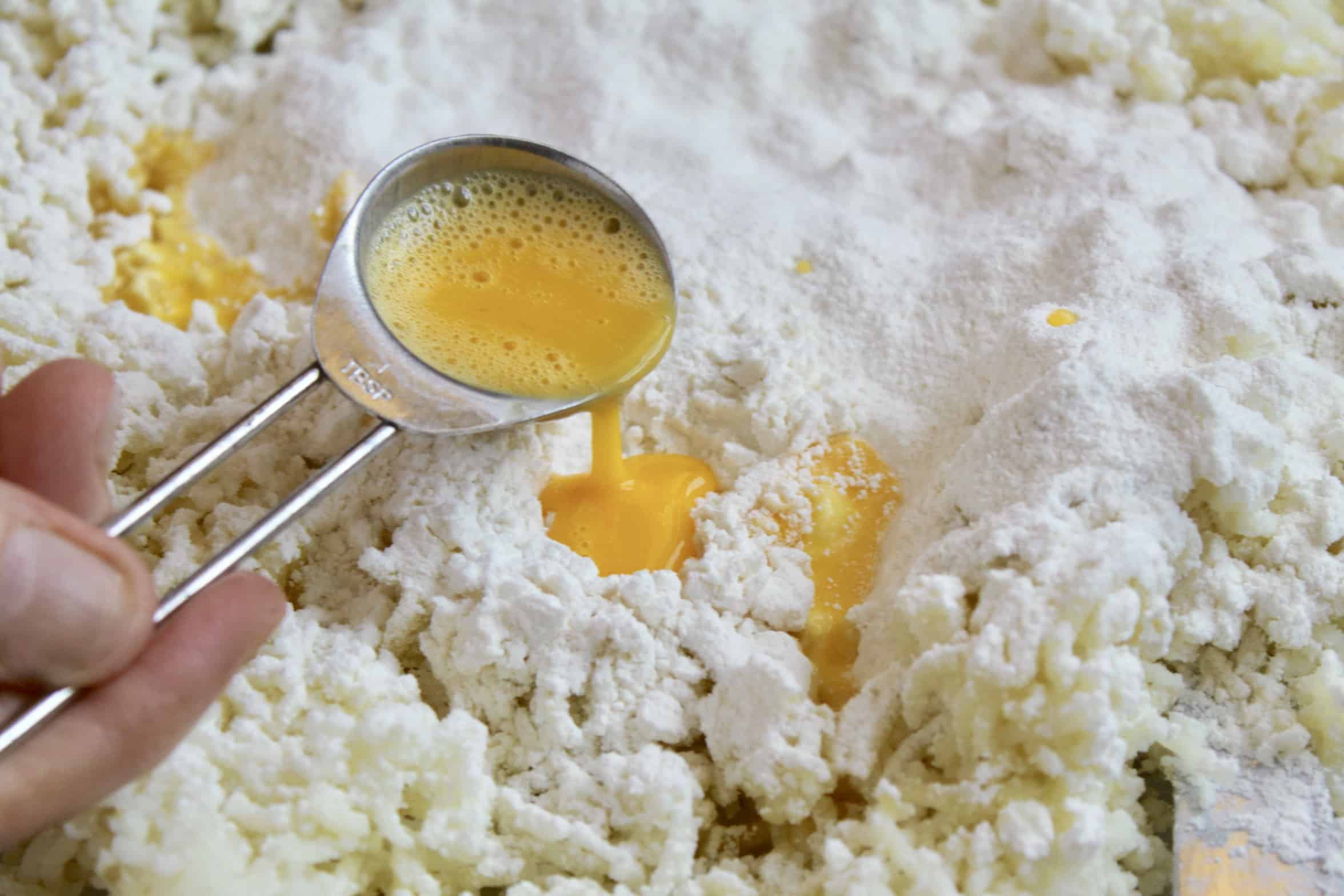 adding beaten egg to potatoes and flour