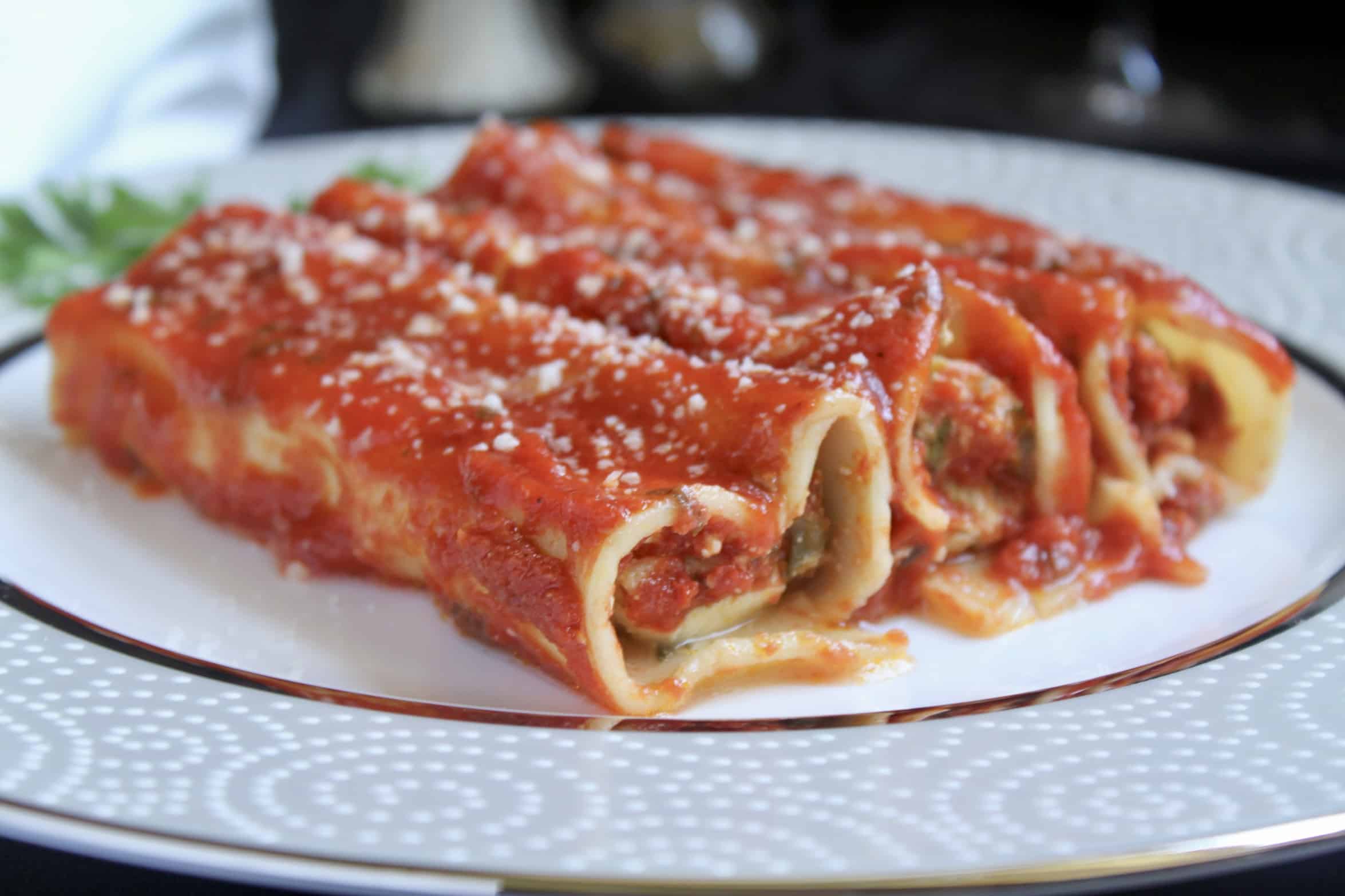 three manicotti on a fine china plate