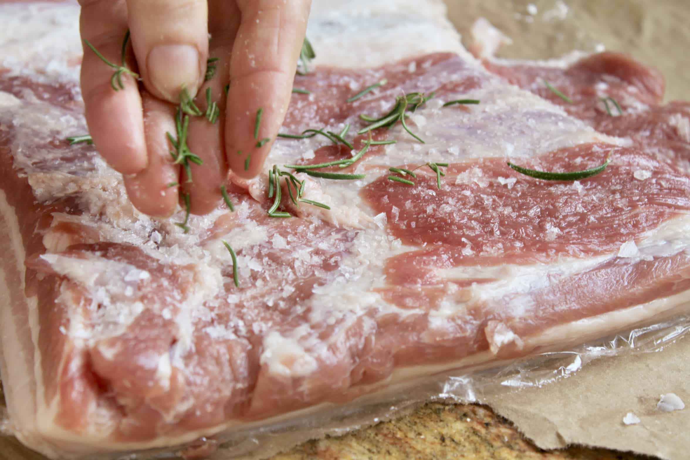 adding rosemary to porchetta