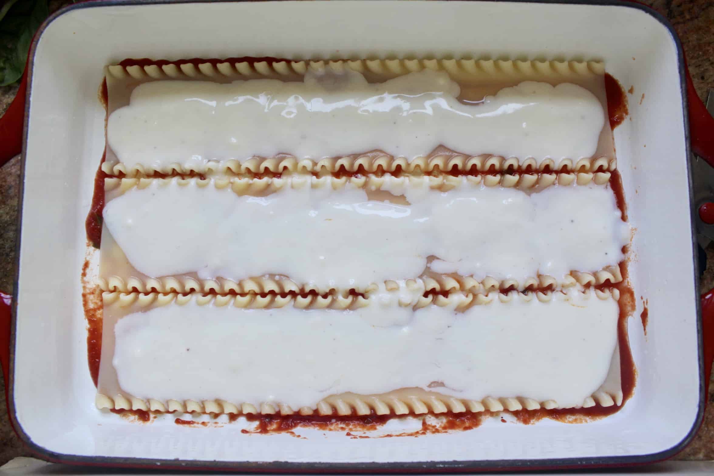 making lasagna layers with bechamel on top