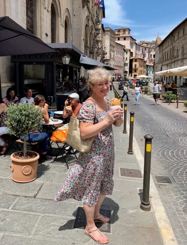 Christina eating porchetta on the street in Perugia, Italy