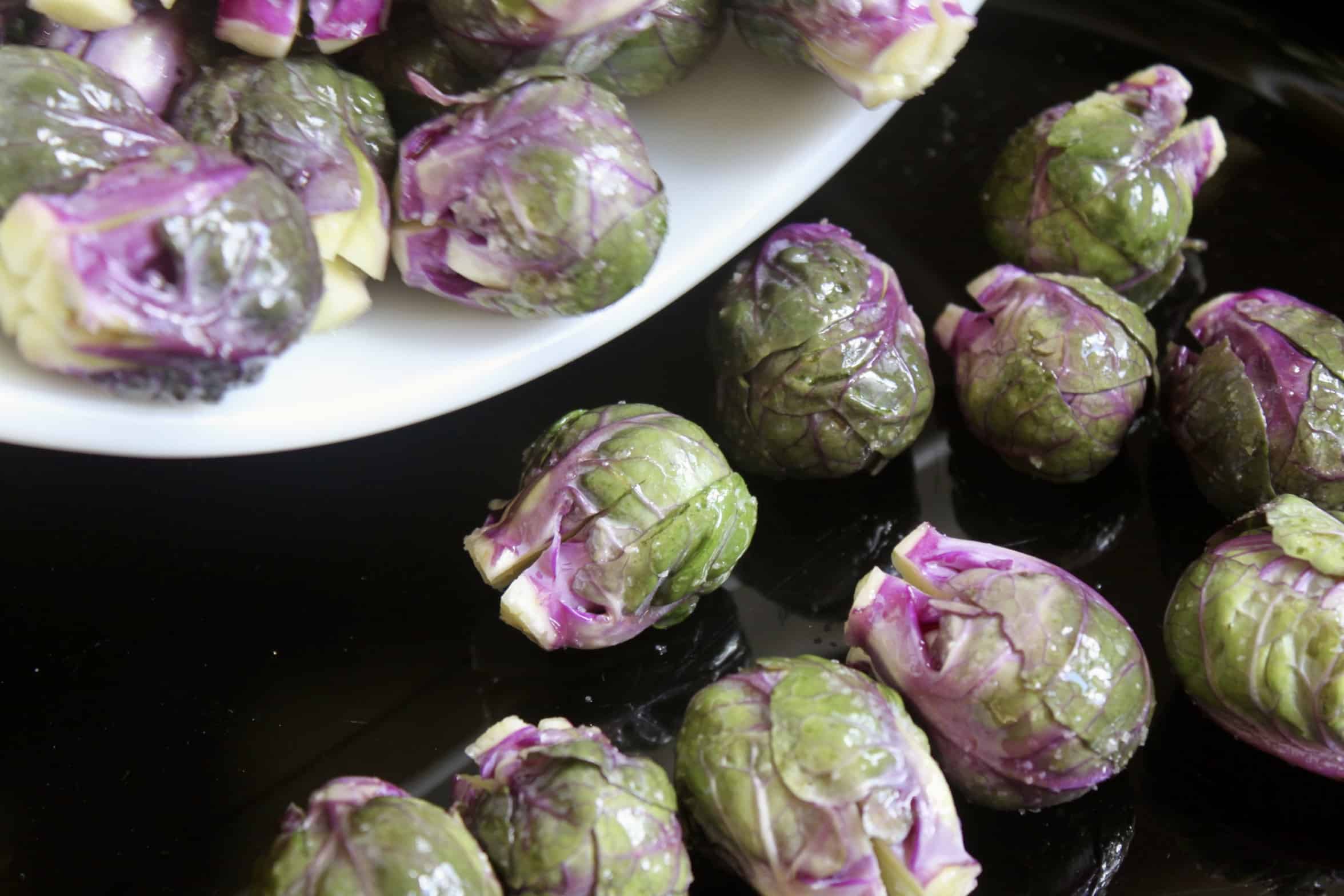 adding sprouts onto a baking pan