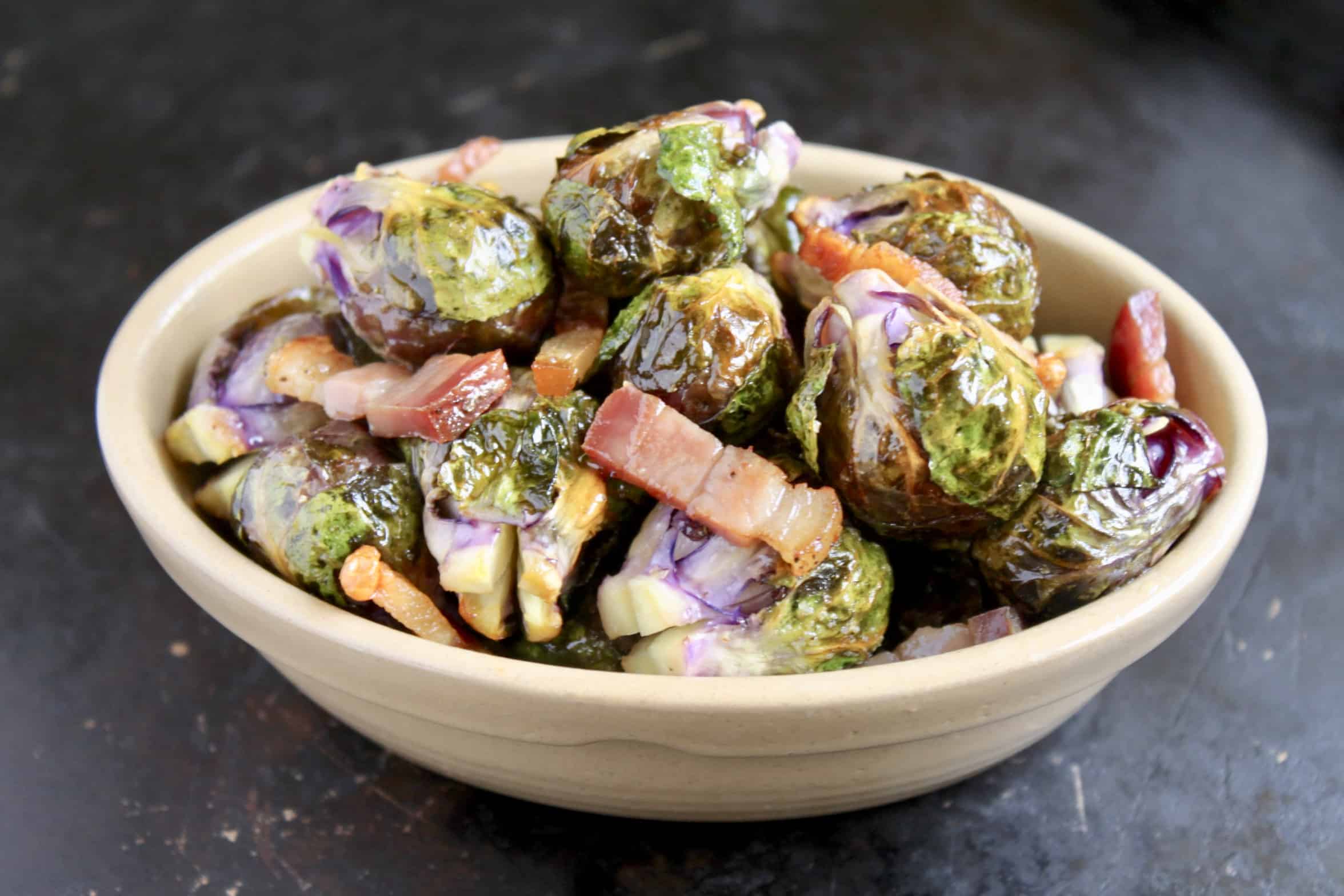 roasted brussels sprouts with pancetta in an oval dish